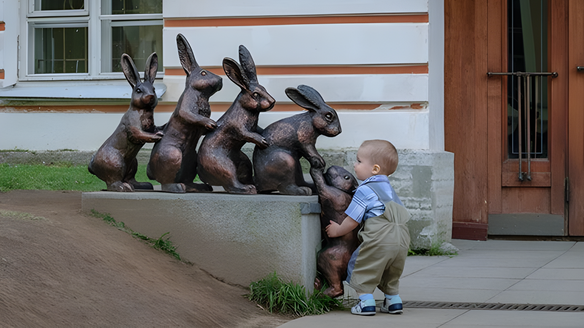 Children showing an act of kindness by helping a statue of rabbits